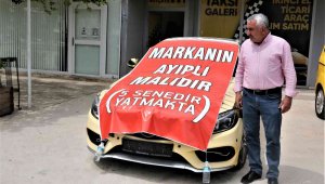 Aldığı lüks aracı işyerinin önüne koyup, üzerine "Markanın ayıplı malıdır, 5 yıldır yatmakta" yazdı